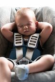 foto of infants  - Infant boy sleeps peacefully secured with seat belts while in the car - JPG 