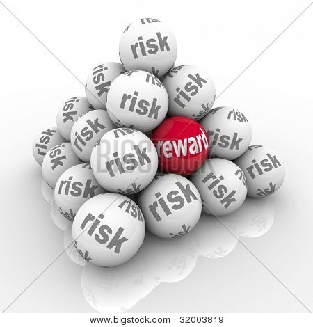 Picture or Photo of A pyramid of stacked balls each marked Risk with one reading Reward symbolizing the hidden benefits of taking a risk and overcoming a challenge with a great return on your investment of effort