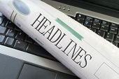 stock photo of newspaper  - headlines section of the newspaper laying on a laptop - JPG 