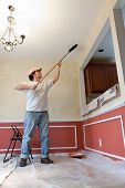 stock photo of construction worker  - Man painting the ceiling of room with a roller - JPG 