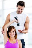 image of fitness  - Fit woman at the gym with a personal trainer - JPG 