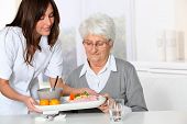 picture of health  - Beautiful nurse bringing meal tray to old woman at nursing home - JPG 