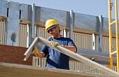 image of construction worker  - A construction worker bending piece of metal - JPG 