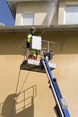 stock photo of pressure  - A man working with a lift and pressure washer - JPG 