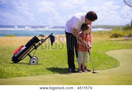 Picture or Photo of Father teaching his son how to play golf.