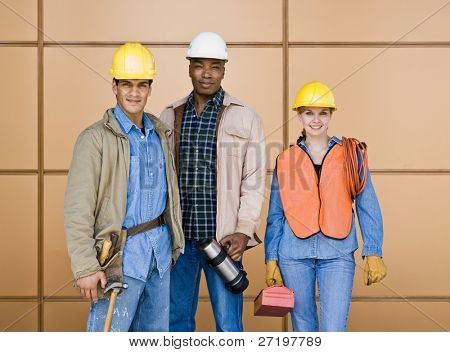Picture or Photo of Multi-ethnic construction workers posing in hard-hats with tools
