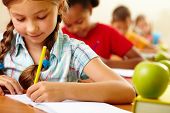 picture of youngster  - Portrait of lovely girl drawing in copybook at lesson - JPG 
