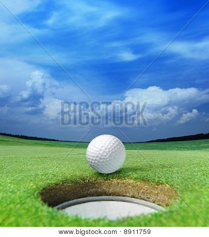 Picture or Photo of Golf ball on lip of cup of lovely beautiful golf course