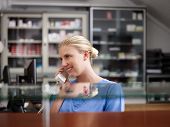 stock photo of receptionist  - Young woman at work as receptionist and nurse in hospital and talking on the phone - JPG 