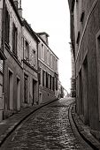 picture of france  - Small and narrow village cobblestone paved street with traditional French city houses in an incline hill downtown area in France - JPG 