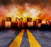 foto of sunset  - A double yellow line road is leading to a city with a red and yellow sunset in the background - JPG 