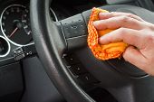 picture of interior  - polishing the car interior steering wheel with yellow duster - JPG 