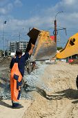 stock photo of construction worker  - Worker and road loader on construction of road - JPG 