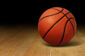 picture of competition  - Basketball on a hardwood court floor as a sports and fitness symbol of a team leisure activity playing with a leather ball dribbling and passing in competition tournaments - JPG 