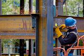 stock photo of construction worker  - A construction worker welding an iron beam - JPG 