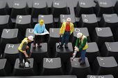 stock photo of computer  - Miniature construction workers repairing a computer keyboard - JPG 