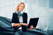 pic of business people  - Young businesswoman with laptop against office windows - JPG 