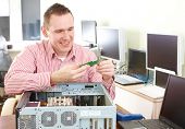 stock photo of hardware  - Repairman working with computer with a part in hands - JPG 