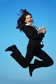 picture of blue sky  - A beautiful young businesswoman jumping in front of a blue sky - JPG 