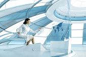 stock photo of future  - Sexy brunette operating transparent future touch interface - JPG 