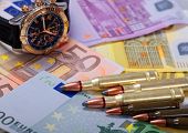 stock photo of watch  - bullets and watch lying on euro banknotes background - JPG 