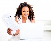 picture of finance  - Woman paying bills online from home and smiling - JPG 