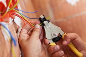 pic of wire  - Electrician peeling off insulation from wires  - JPG 
