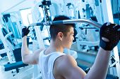 stock photo of pulldown  - asian man using lat pulldown machine in gym - JPG 