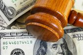 stock photo of cash  - closeup of a legal gavel on cash from above - JPG 