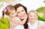 stock photo of nature  - Picture of young mother hugging two little children - JPG 