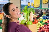picture of food  - Young woman holding a grocery bag full of fresh and healthy food inside a supermarket - JPG 