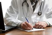 picture of medical  - Doctor writing patient notes on a medical examination or prescription - JPG 