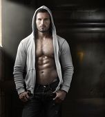 picture of industrial  - Young handsome macho man with open jacket revealing muscular chest and abs in industrial garage with window light - JPG 