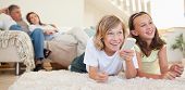 stock photo of interior  - Siblings lying on the floor watching tv together - JPG 