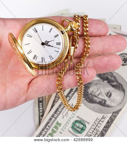 Picture or Photo of Hand holding a watch with money in the background