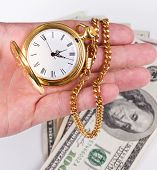stock photo of watch  - hand holding a watch with money in the background - JPG 