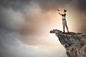 stock photo of future  - Image of businesswoman looking in telescope standing atop of rock - JPG 