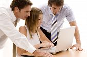 stock photo of team  - a business team working on a laptop computer - JPG 