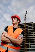 picture of construction worker  - Construction supervisor in safety helmet and reflex vest in front of construction site - JPG 