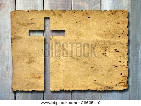 Picture or Photo of High resolution christian cross cut in an old grungy or vintage paper, over a wood background, ideal for religion, Christian, grunge or conceptual designs