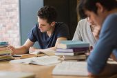 pic of college  - People sitting at the table while doing homework in college library - JPG 