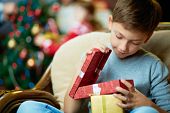 picture of boy  - Portrait of adorable boy with giftboxes looking into one of them - JPG 