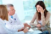 foto of medical doctors  - Portrait of two practitioners consulting patient with headache in hospital - JPG 