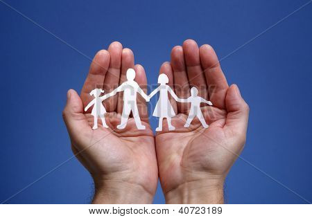 Picture or Photo of Cutout paper chain family with the protection of cupped hands, concept for security and care