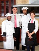 picture of staff  - four happy restaurant staff inside industrial kitchen - JPG 