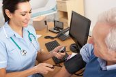 stock photo of pressure  - British nurse taking senior man - JPG 