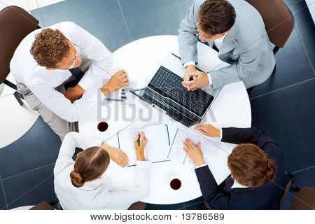 Picture or Photo of Above view of several business people planning work at round table