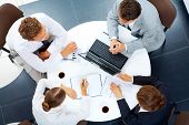 picture of meeting  - Above view of several business people planning work at round table - JPG 