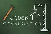 image of construction  - Construction Site drawn on a blackboard and a hammer - JPG 