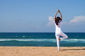 image of beach  - young woman doing yoga on beach - JPG 